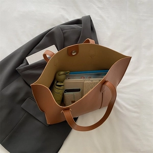 Top view of spacious brown tote bag with magnetic closure holding daily essentials