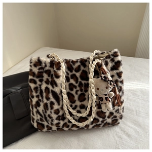Dettaglio borsa tote leopardata in peluche con manici intrecciati e ciondolo a gatto