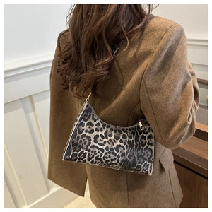 Detail of leopard print underarm bag with gold zipper on vintage brown blazer