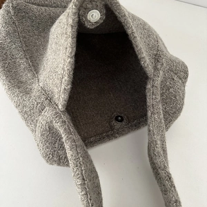 Nahaufnahme einer grauen Woll-Tote-Bag mit Magnetverschluss und weicher Plüschtextur