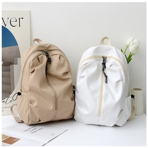 Lifestyle shot of khaki and white nylon backpacks with vertical zipper and side buckles