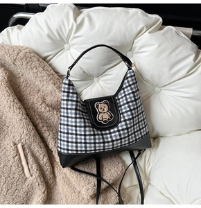 Detail shot of the 3D bear embroidery on a plaid canvas tote with black leather trim