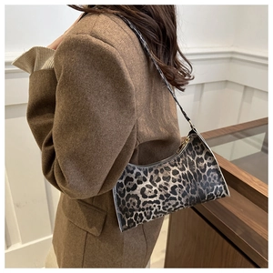Detail of leopard print shoulder bag in synthetic leather texture with sleek strap