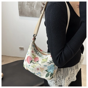 Detail view of ethnic floral jacquard canvas tote with wide strap on model shoulder