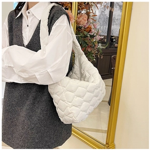 Elegante borsa shopper trapuntata abbinata a camicia bianca e gilet di maglia grigio