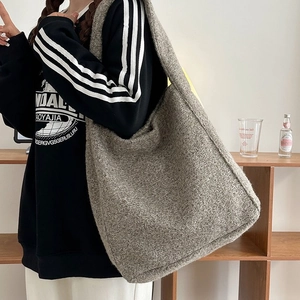 Detailstruktur der grauen Tweed-Woll-Tragetasche mit weichem Stoff und großem Inhalt