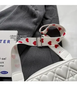 Détail du sac bandoulière blanc matelassé cœur avec sangle ajustable à motifs cœurs