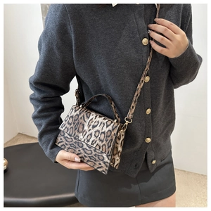 Modell mit Vintage-Handtasche mit Leopardenmuster, Metallschloss und schmalem Riemen