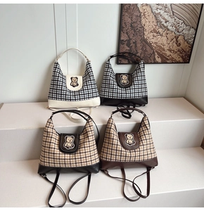 Close-up of four plaid canvas tote bags with cute bear embroidery on display stands