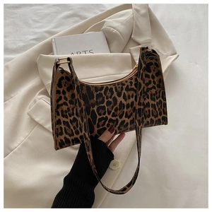 Detail of leopard print faux leather underarm bag with zipper closure on neutral background