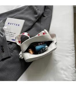 Vue intérieure d'un sac bandoulière blanc matelassé avec espace pour parfum et batterie