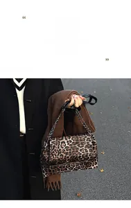 Détail du sac à bandoulière léopard avec chaîne en métal argenté sur un sol d'automne