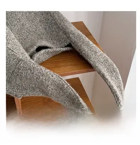 Detail des strukturierten Wollstrickgriffs einer dunkelgrauen Tragetasche auf Holzständer