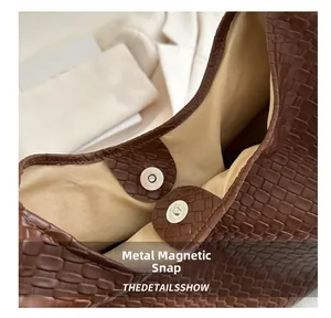 Détail du fermoir magnétique et texture tissée sur le sac cabas marron en similicuir