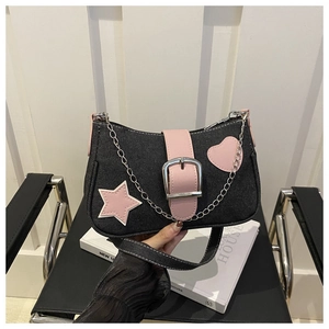 Détail du sac d'épaule en denim avec patch étoile rose et boucle en métal argenté