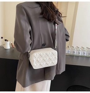 Détail du sac bandoulière blanc matelassé cœur avec sangle imprimée sur modèle