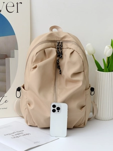 Minimalist beige backpack with pleated texture and side pockets for casual travel and school