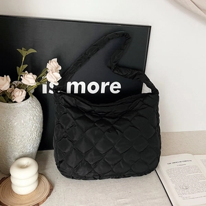 Grande borsa hobo nera trapuntata con ampia tracolla in uno stile minimalista