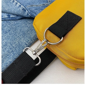 Detail of the silver metal lobster clasp and D-ring on the yellow cartoon bag strap