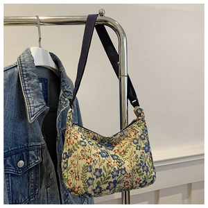 Detail view of ethnic floral jacquard fabric on crescent-shaped underarm shoulder bag