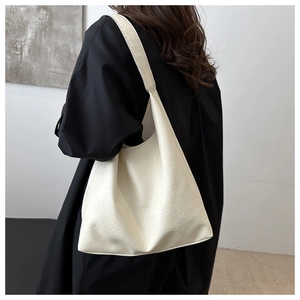 White minimalist tote bag with soft pleated texture shown on model's shoulder for daily use