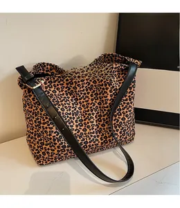 Détail de la bandoulière réglable en cuir noir avec boucle sur sac fourre-tout léopard