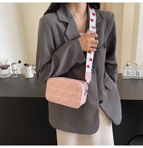 Gros plan détaillé du sac bandoulière rose matelassé en cœurs avec bandoulière large