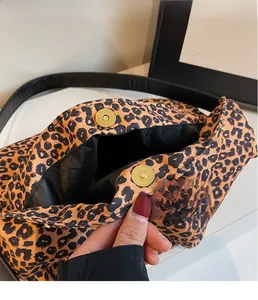 Détail d'un sac à bandoulière léopard avec un fermoir magnétique doré de qualité