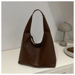 Gros plan sur le sac cabas tissé marron foncé avec des détails de texture de tissage croisé