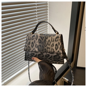 Detail der grauen Handtasche mit Leopardenmuster, goldener Hardware und Tragegriff