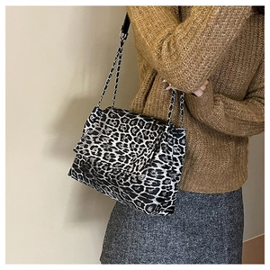 Détail d'un sac léopard avec bandoulière chaîne argentée porté par un mannequin