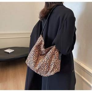 Gros plan du grand sac hobo léopard avec bandoulière en cuir noir et effet daim