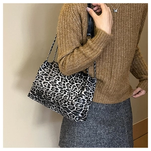 Détail d'un sac bandoulière léopard tendance avec bandoulière chaîne sur modèle