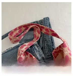 Detail of pink heart leopard print canvas bag featuring wide reinforced shoulder strap