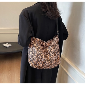 Sac bandoulière chic à motif léopard porté par un mannequin sur fond blanc épuré