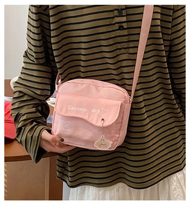 Pink nylon crossbody bag with Sausage dog illustration and a cute charm accessory