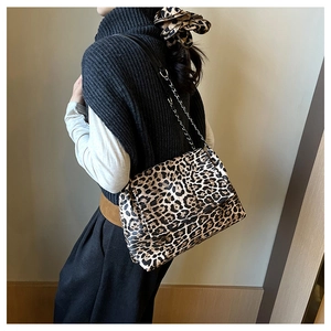 Détail du sac à main léopard avec bandoulière chaîne et accessoire cheveux assorti