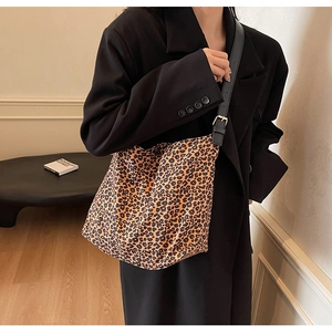 Détail de la bandoulière réglable en cuir noir avec boucle dorée sur le sac hobo léopard