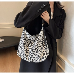 Détail du sac à bandoulière en suédine léopard avec fine lanière noire et grande capacité