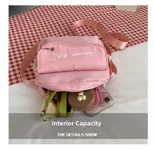 Internal capacity of the pink canvas crossbody bag showing phone and cosmetics