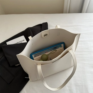 Spacious white leather tote bag interior view showing storage for laptop and umbrella