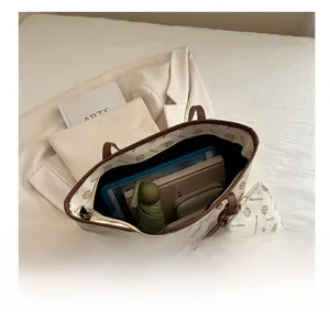 Detail view of large tote bag with inner pouch showing spacious interior and items