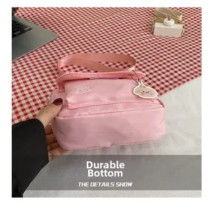 Detail of pink canvas crossbody bag showing durable thickened bottom and animal print