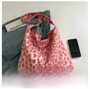 Detail of pink leopard print canvas tote bag with broad shoulder strap in casual setting