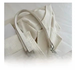 Detail showing high-quality silver hardware and snakeskin textured cream tote bag