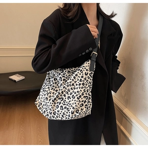 Détail d'un grand sac cabas à imprimé léopard avec bandoulière en cuir et boucles d'or