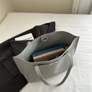 Top view of spacious grey tote bag interior showing laptop and umbrella storage