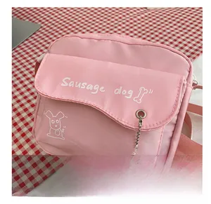 Detailed shot of pink canvas crossbody bag featuring sausage dog print and pearl chain
