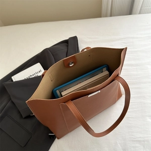 Macro view of the large caramel tote bag interior with magnetic closure and front pocket
