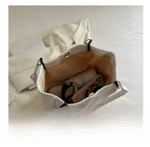 Top view of large capacity white quilted tote bag filled with daily essentials